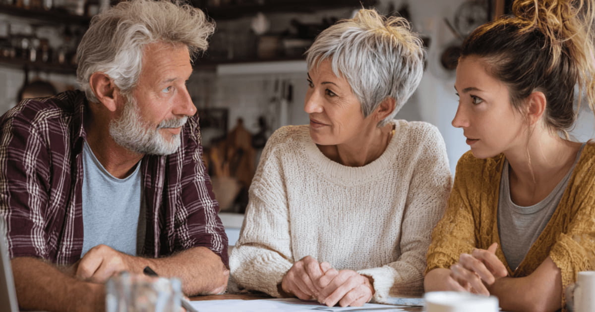 "Senior couple having a serious conversation with adult daughter about downsizing decisions"